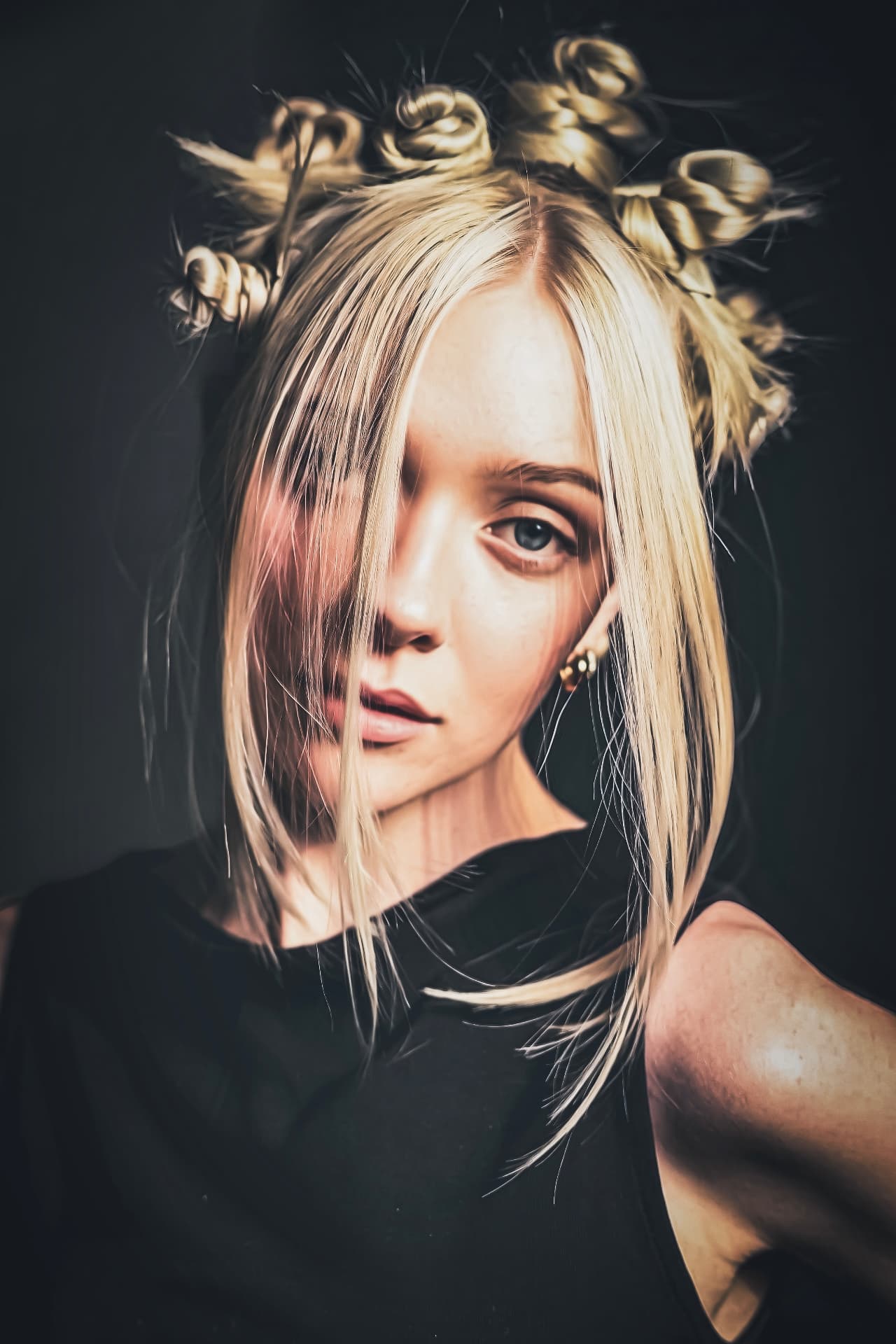 Blonde hair styled into sculpted knots with a soft face-framing fringe